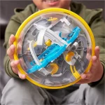 Kind hält einen transparenten Spielzeug-Helikopter mit blauen, weißen und gelben Elementen, der die mechanischen Details und beweglichen Teile zeigt.