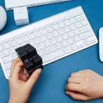 Wissenschaftliches Gadget auf einem Schreibtisch mit weißen und schwarzen Würfeln, Tastatur und anderen Büroartikeln, ideal für Dekoration und wissenschaftliche Themen.