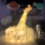 Detailliertes Modell einer Rakete mit Rauch, umgeben von Astronautenfiguren, ideal für wissenschaftliche Dekorationen und Lernzwecke.