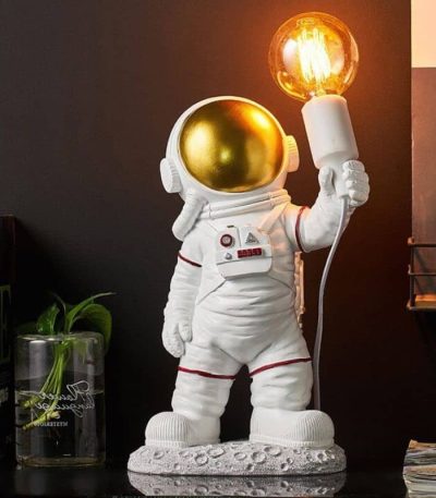 Niedliche Raumfahrerfigur mit goldenem Helm, die eine leuchtende Glühbirne hält, ideal für Science-Fiction- und Weltraumdekorationen.