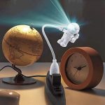 Kreativer Sternenprojektor, der einen Globus beleuchtet, neben einem klassischen Wecker auf einem Schreibtisch. Perfekt für Wissenschafts- und Dekorationsliebhaber.