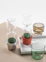Dekorative Blumen im Sanduhr-Design, bestehend aus Glas und Terrakotta, ideal für wissenschaftliche oder moderne Raumdekorationen.
