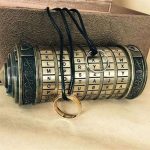 Vintage-Schlüsselanhänger mit integriertem Verschlüsselungsgerät, das Buchstaben- und Zahlencodes anzeigt, ideal für Science-Fiction- und Geheimnisspiel-Enthusiasten.