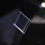 Nahaufnahme eines transparenten, rechteckigen optischen Kristalls mit reflektierenden Oberflächen, ideal für wissenschaftliche Dekorationen und Experimente.