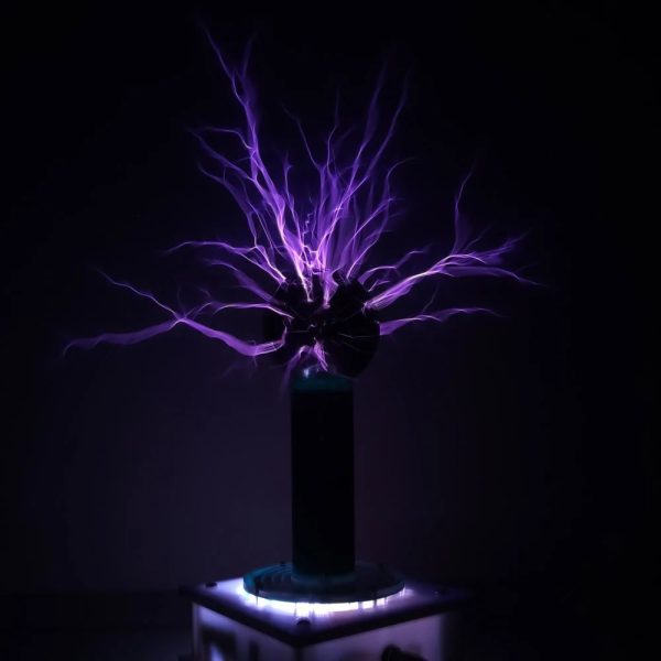 Elektrischer Plasma-Entladungsexperiment mit bläulichen Blitzen, die aus einer Kugel aufsteigen, auf einem dunklen Hintergrund.