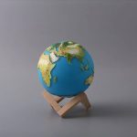 Miniatur-Erde auf Holzständer, zeigt die Kontinente und Ozeane, ideal für wissenschaftliche Dekorationen und Lernzwecke.