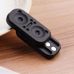 Kleiner schwarzer Lautsprecher-Adapter mit zwei Lautsprecheröffnungen und Anschlussbuchsen, ideal für tragbare Audio-Geräte.