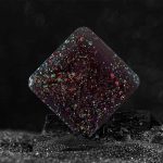 Holografischer Kristall in Sternform mit schillernden, regenbogenartigen Reflexen auf schwarzem Hintergrund, ideal für wissenschaftliche Dekorationen und Sammlerstücke.