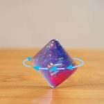 Glitzernder wissenschaftlicher Kristallwürfel mit holografischen Effekten auf Holzuntergrund. Perfekt für Dekoration und wissenschaftliche Sammlungen.