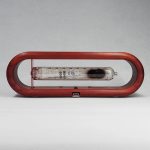 Moderner Feuerlöscher mit transparentem Glasbehälter in einem roten Rahmen, ideal für Sicherheit und Dekoration.