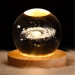 Dekorativer Globus mit Sternen- und Galaxiemotiv in einer Glas-Kugel auf Holzsockel, ideal für wissenschaftliche Dekorationen und Raumgestaltung.