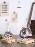 Zwei Glasflaschen mit bunten Kristall- und Glasperlen auf Holzbasen, dekoratives wissenschaftliches Kunstobjekt für Zuhause oder Büro.