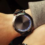 Hochwertige Smartwatch mit kreisförmigem LED-Display, das die Zeit anzeigt, ideal für Technik- und Wissenschaftsbegeisterte.