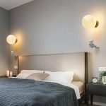 Modernes Schlafzimmer mit zwei Mond-Lampen an der Wand, gemütlichem Bett und wissenschaftlicher Dekoration, ideal für Liebhaber von Wissenschaft und Dekor.