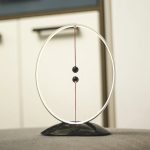 Modernes Präzisionspendel mit schwarzem Basis, weißen Rahmen und rot-weißer Faden, ideal für wissenschaftliche Demonstrationen und Dekorationen.