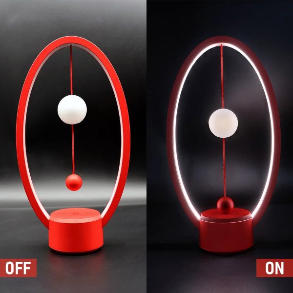Modernes lichtschwebendes Pendel mit rot-weißer Kugel, das im Dunkeln leuchtet, zeigt physikalische Prinzipien der Schwerkraft und Magnetismus.