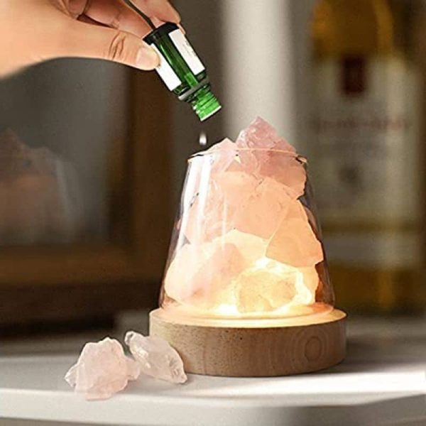 Salzlampe aus Kristall mit ätherischem Öl, die auf einem runden Holzsockel steht, ideal für Dekoration und Wohlbefinden.