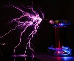 Nahaufnahme einer elektrischen Entladung mit bläulichem Licht, die zwischen zwei Elektroden in einem wissenschaftlichen Experiment entsteht.