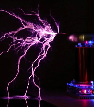 Nahaufnahme einer elektrischen Entladung mit bläulichem Licht, die zwischen zwei Elektroden in einem wissenschaftlichen Experiment entsteht.