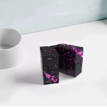 Schwarzes Puzzle-Objekt mit pinken Spritzern, dekoratives wissenschaftliches Kunststück, ideal für moderne Raumgestaltung und Wissenschaftsbegeisterte.