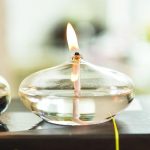 Elegante Glas-Feuerschale mit brennender Kerze, ideal für stilvolle Dekorationen und stimmungsvolle Beleuchtung im Innen- und Außenbereich.