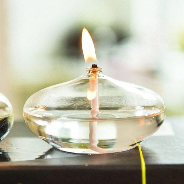 Elegante Glas-Feuerschale mit brennender Kerze, ideal für stilvolle Dekorationen und stimmungsvolle Beleuchtung im Innen- und Außenbereich.