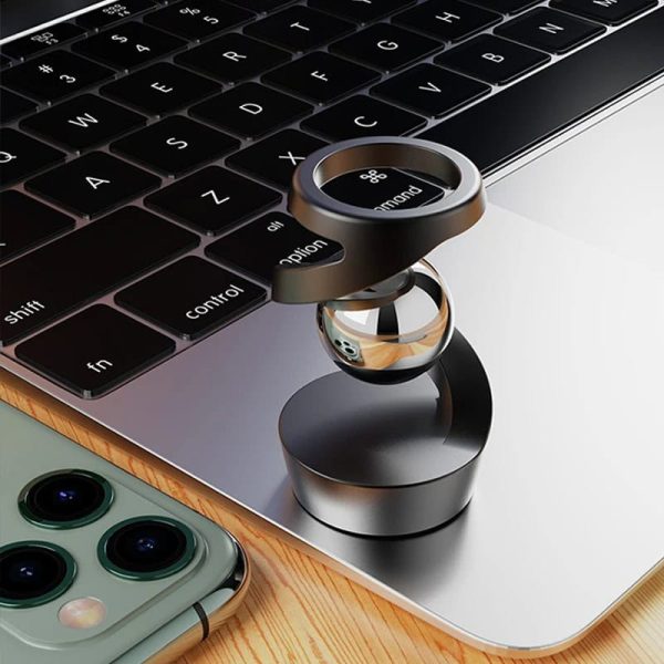 Modernes wissenschaftliches Gadget mit Metallring und Smartphone auf einem Laptop, ideal für Technik- und Wissenschaftsbegeisterte.