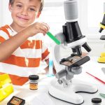 Kind benutzt Mikroskop, um Proben zu untersuchen, fördert Wissenschaftsinteresse und Beobachtungsgabe bei Kindern.