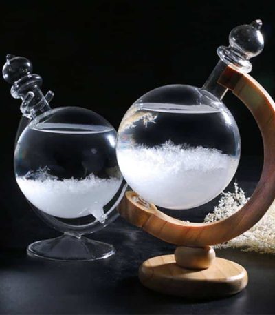 Elegante Glasflasche mit Kristallen, präsentiert auf einem Holzständer, ideal für wissenschaftliche Dekorationen und Sammlerstücke.