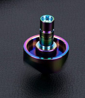 Bunter wissenschaftlicher Glasobjekt, das auf einer schwarzen Oberfläche liegt, mit reflektierenden, regenbogenfarbenen Effekten.