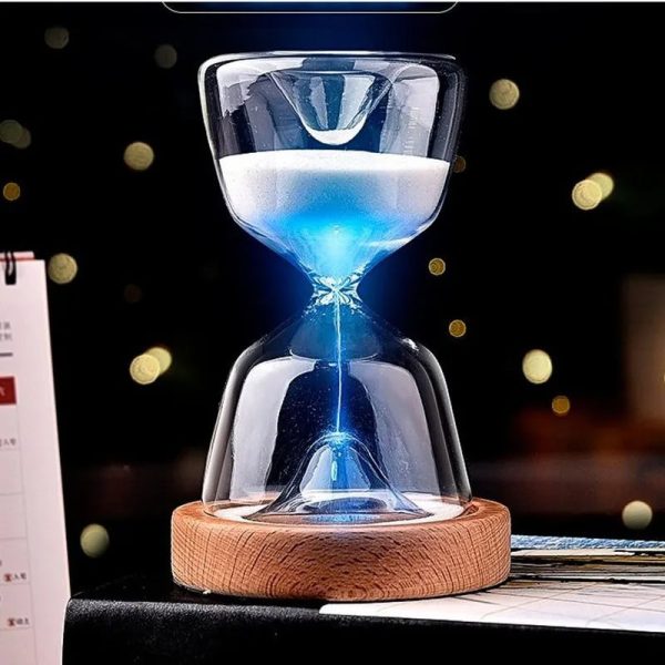 Sanduhr mit blauer Flüssigkeit, die durch die Mitte fließt, auf einem Holzsockel, dekoratives wissenschaftliches Gadget.