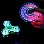 Leuchtender Fidget Spinner in der Hand, der im Dunkeln mit bunten LED-Lichtern leuchtet, ideal für Wissenschafts- und Dekorationszwecke.