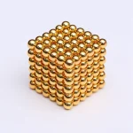 Ein 3D-Modell eines goldfarbenen Kugelwürfels, bestehend aus kleinen, glänzenden Metallkugeln, die zu einer geometrischen Struktur verbunden sind.