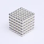 Ein 3D-Magnetwürfel aus kleinen, glänzenden Metallkugeln, die zu einem Würfel verbunden sind, ideal für wissenschaftliche Dekorationen und Geduldsspiele.