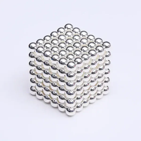 Ein 3D-Magnetwürfel aus kleinen, glänzenden Metallkugeln, die zu einem Würfel verbunden sind, ideal für wissenschaftliche Dekorationen und Geduldsspiele.