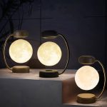 Stilvolle Mondlampen mit goldenen Halterungen, die eine warme Beleuchtung für eine gemütliche Atmosphäre schaffen. Perfekt als Dekoration oder Nachtlicht in modernen Wohnräumen.