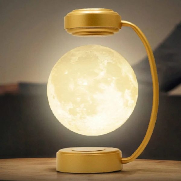 Kreative Tischlampe in Mondform mit goldfarbenem Lampenschirm und flexiblem Arm, ideal als dekoratives Lichtstück für moderne Wohnräume.