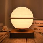 Modernes Lichtobjekt in Kugelform mit Ringdekor, auf Holzbasis, warmes Licht, dekoratives wissenschaftliches Design, ideal für stilvolle Raumgestaltung.
