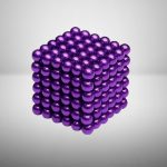 3D-Modell eines metallischen Kristallwürfels aus glänzenden, violetten Kugeln, die perfekt angeordnet sind, um eine geometrische Struktur zu bilden.
