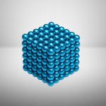 Dreidimensionaler Würfel aus glänzenden blauen Metallkugeln, die eine geometrische Struktur bilden.