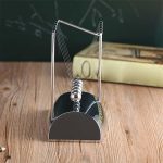 Newtons Kugelbahn aus Metall auf Holzoberfläche, ideal für Physik-Experimente und wissenschaftliche Dekorationen.