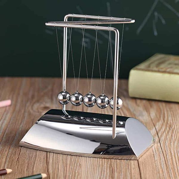 Newton-Wiege aus Metall mit Kugeln, wissenschaftliches Dekor, ideal für Bildung und Experimente, auf Holzoberfläche.