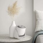 Moderner Luftbefeuchter auf Nachttisch neben Vase mit Trockenblumen, ideal für Raumluftverbesserung und Dekoration.
