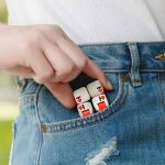 Nahaufnahme eines Würfelspiels mit wissenschaftlichem Thema, das in der Tasche einer Person steckt, die Jeans trägt, im Freien.
