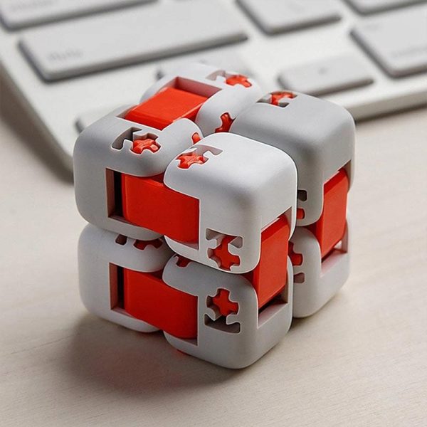 Modernes 3D-Puzzle Würfel mit weißen und roten Teilen, ideal für Denksport und Gehirntraining, auf einem Schreibtisch mit Tastatur im Hintergrund.