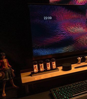 Moderne wissenschaftliche Dekoration mit LED-Lichtern, die auf einem Holzregal vor einem digitalen Bildschirm mit bunten, dynamischen Mustern präsentiert wird.