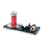 Wissenschaftliches Experiment mit Elektromagnet, Spule und Batterie auf einer schwarzen Basis. Perfekt für Bildung und Dekoration.