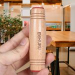 Hand hält einen Holz-Kerzenhalter mit rotem Rand, ideal für wissenschaftliche Dekorationen und Gadgets. Perfekt für ein modernes, stilvolles Ambiente.