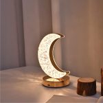 Kreative Mondlampe mit goldener Basis, die sanft im Raum leuchtet, ideal für Dekoration und stimmungsvolle Beleuchtung.