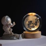 Deko-Objekt mit Mondplanet in Glaskugel und Astronautenfigur auf Mondlandschaft, ideal für wissenschaftliche Dekorationen und Sammler.